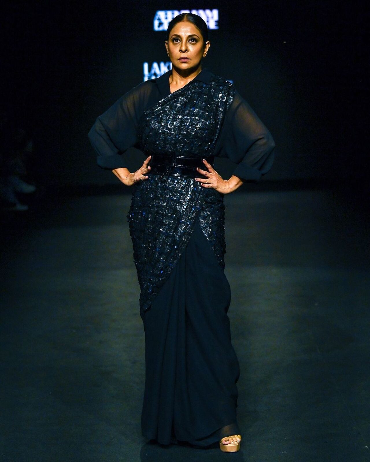 The seasoned performer graced the runway in an all-black shimmer sari, adorned with a long-sleeved blouse and a black belt cinching her waist. What made the outfit even more remarkable was its origin--David revealed that the sari was crafted from bin bags, with sequins made from discarded x-rays.